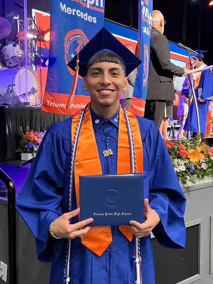 TPHS graduate student wearing cap and gown holding diploma.